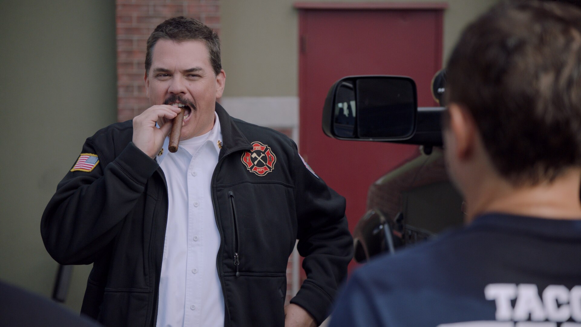 Tacoma FD Chief Terry McConky stands with a cigar in his mouth in front of his new black truck.